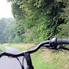 Blick über einen Fahrradlenker auf einen Radweg, der parallel zur B 51 verläuft