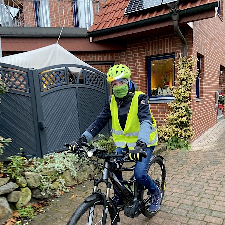 Marius Brünen auf dem Fahrrad vor einem Haus>